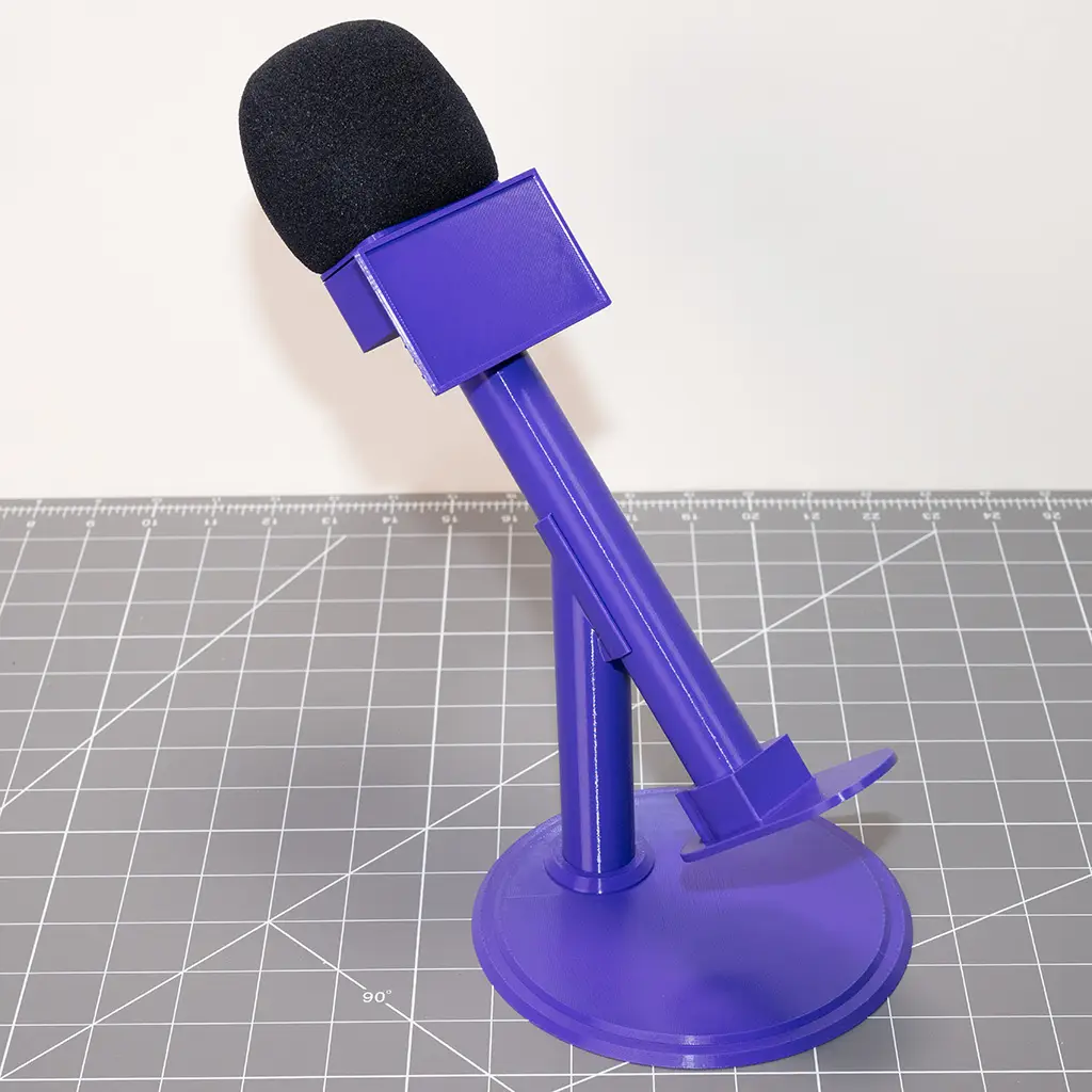 A completely assembled purple colored Influencer Handle on a matching desktop stand.